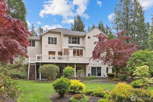 back of property featuring stairway, a deck, and a yard
