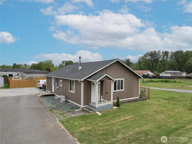 view of front of house with a shingled roof, central air condition unit, and driveway