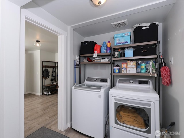 laundry area with washer and clothes dryer, wood finished floors, and baseboards