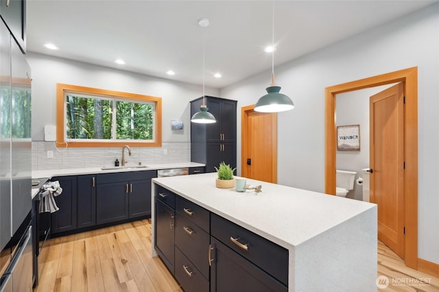 7467 Canyon View Dr, Deming, WA 98244 - kitchen featuring a sink, light wood finished floors, decorative backsplash, light countertops, and recessed lighting