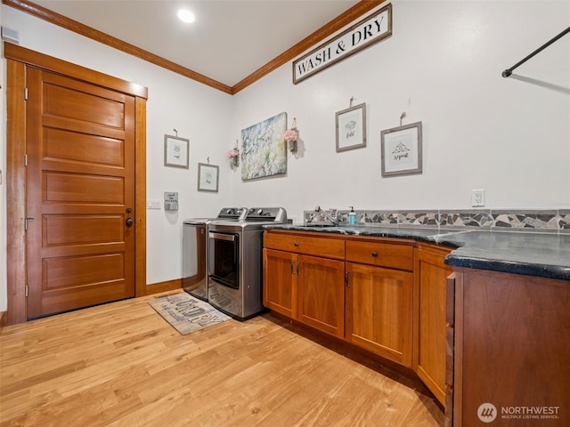 28235 SE 268th St, Ravensdale, WA 98051 - laundry room with light wood-type flooring, ornamental molding, cabinet space, and washer and clothes dryer