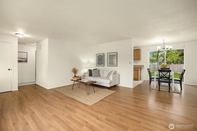 26692 Weaver Ave NW, Poulsbo, WA 98370 - living room with a chandelier, light wood-style floors, and baseboards