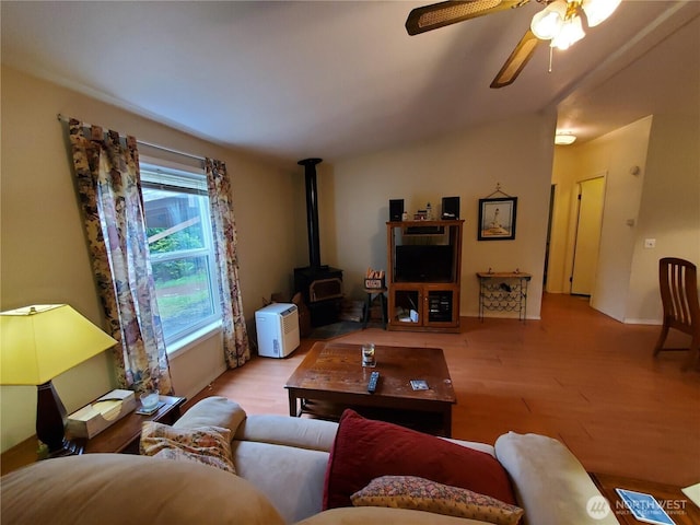669 Duck Lake Dr NE, Ocean Shores, WA 98569 - living room featuring a wood stove, wood finished floors, ceiling fan, baseboards, and lofted ceiling