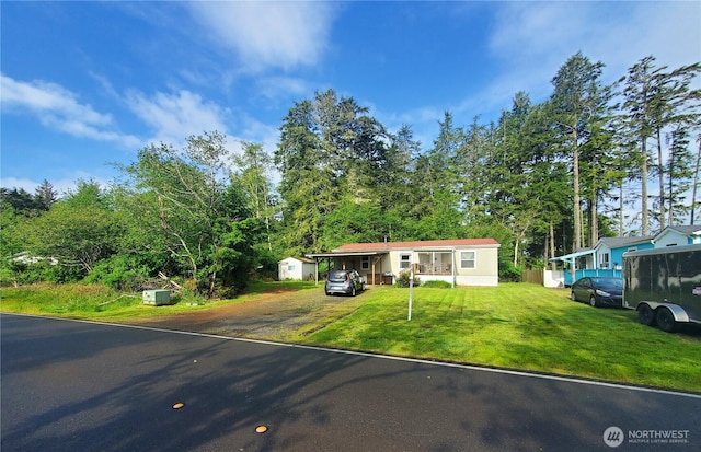 669 Duck Lake Dr NE, Ocean Shores, WA 98569 - manufactured / mobile home featuring driveway, a front lawn, and a storage unit