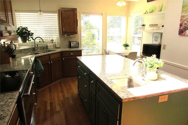 1427 100th St SW Unit 149, Everett, WA 98204 - kitchen featuring electric range, a sink, a center island with sink, and dark wood-style flooring
