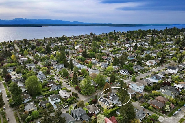 aerial view of property's location with a water and mountain view and nearby suburban area