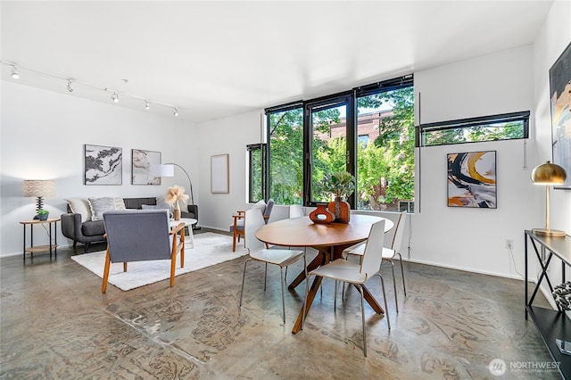 dining area featuring finished concrete flooring and baseboards