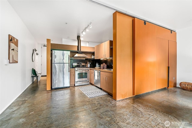 kitchen featuring stainless steel appliances, wall chimney range hood, rail lighting, and light countertops
