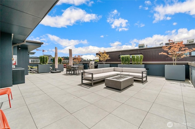 view of patio with an outdoor living space with a fire pit