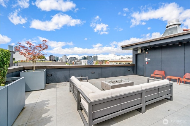 view of patio featuring an outdoor living space with a fire pit and a city view