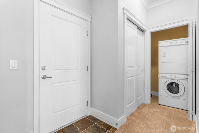 1015 Railroad Ave Unit 415, Bellingham, WA 98225 - washroom featuring estacked washer and dryer, baseboards, dark colored carpet, and ornamental molding