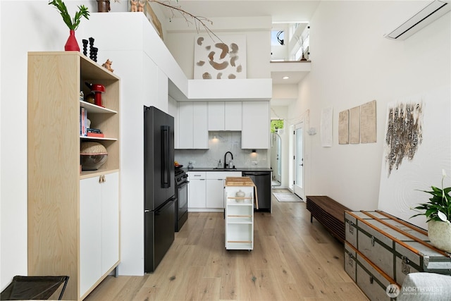 916NW 56th St Unit G, Seattle, WA 98107 - kitchen with an AC wall unit, black appliances, white cabinets, dark countertops, and open shelves