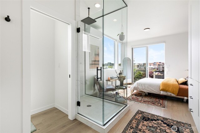 916NW 56th St Unit G, Seattle, WA 98107 - bathroom featuring wood finished floors, a shower stall, ensuite bathroom, and baseboards