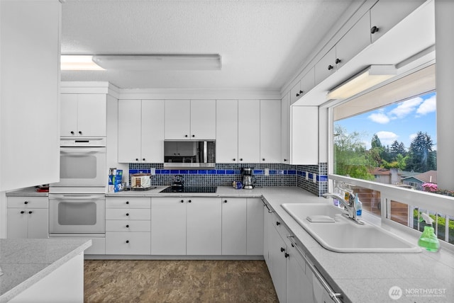 7618 19th St W, Tacoma, WA 98466 - kitchen with white double oven, a sink, white cabinetry, black electric stovetop, and a textured ceiling