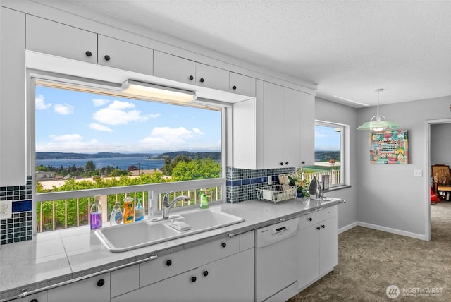 7618 19th St W, Tacoma, WA 98466 - kitchen with white dishwasher, a sink, decorative backsplash, white cabinets, and a textured ceiling