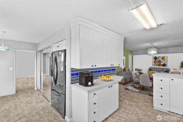 7618 19th St W, Tacoma, WA 98466 - kitchen with black fridge with ice dispenser, light countertops, a textured ceiling, white cabinetry, and pendant lighting