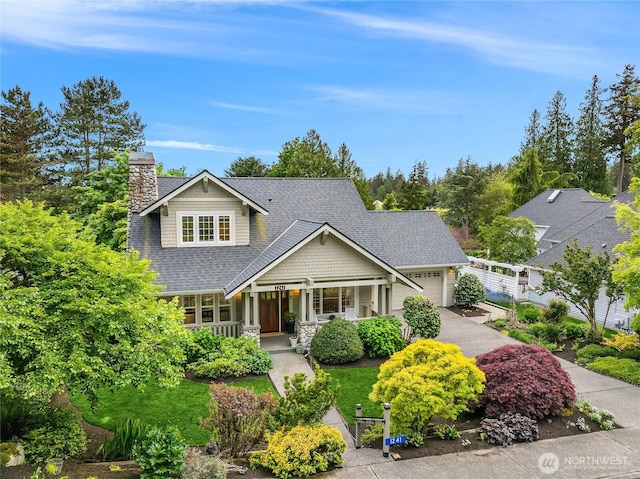 1241 Cherry Ave NE, Bainbridge Island, WA 98110 - craftsman-style home featuring a porch, asphalt driveway, an attached garage, a shingled roof, and stone siding