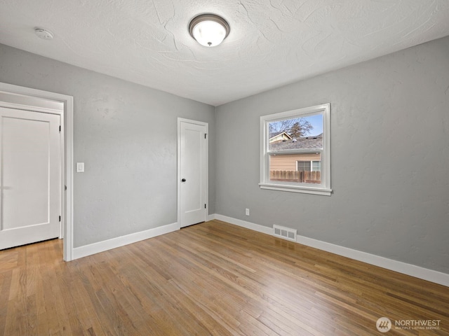 unfurnished bedroom featuring wood finished floors and baseboards