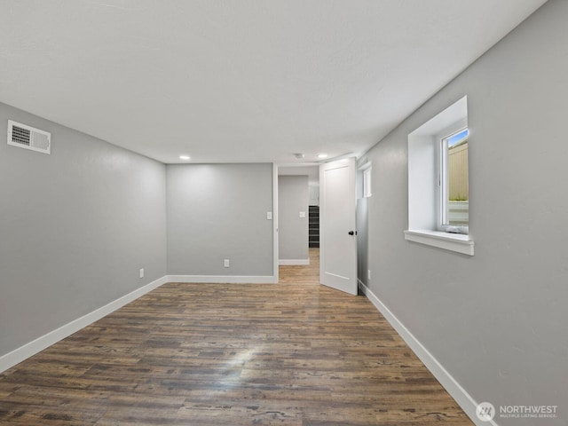 below grade area featuring dark wood-type flooring, recessed lighting, and baseboards