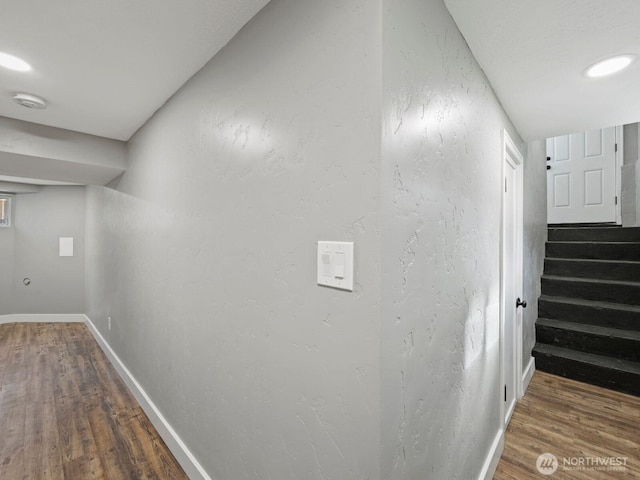 hall with wood finished floors, baseboards, and stairway