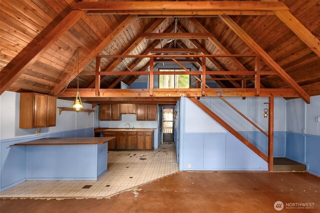 140 Sunstone Rd, Packwood, WA 98361 - kitchen with a sink, brown cabinets, decorative light fixtures, vaulted ceiling, and a peninsula
