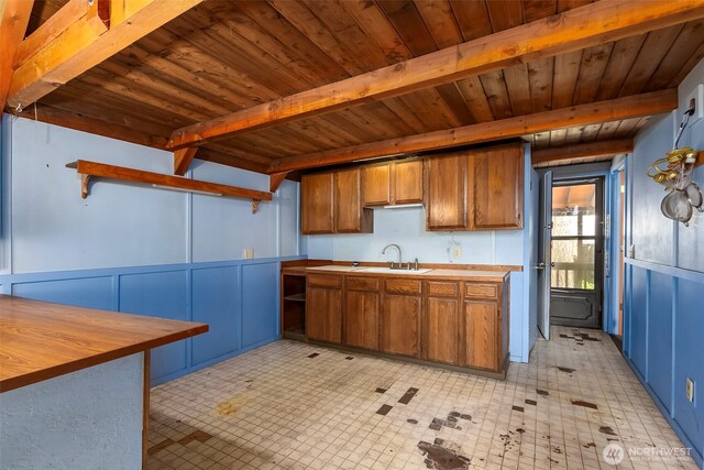 140 Sunstone Rd, Packwood, WA 98361 - kitchen featuring beam ceiling, a sink, wooden ceiling, brown cabinets, and a decorative wall