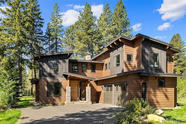 1591 Coal Mine Way, Cle Elum, WA 98922 - contemporary home with board and batten siding, asphalt driveway, a garage, and a chimney