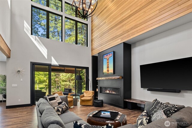 1591 Coal Mine Way, Cle Elum, WA 98922 - living room featuring a towering ceiling, a chandelier, wood finished floors, and a glass covered fireplace