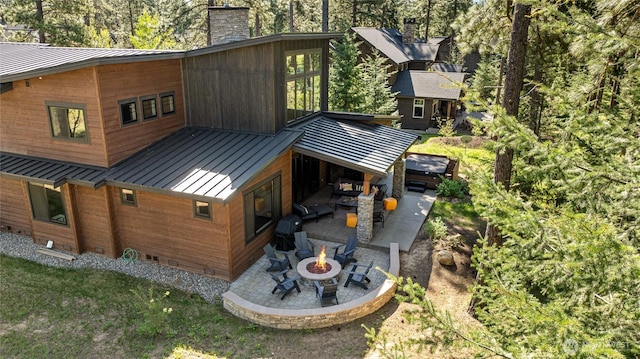 1591 Coal Mine Way, Cle Elum, WA 98922 - rear view of property featuring a standing seam roof, a patio area, a fire pit, a chimney, and metal roof