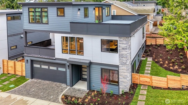 view of front of home featuring fence, a garage, and decorative driveway