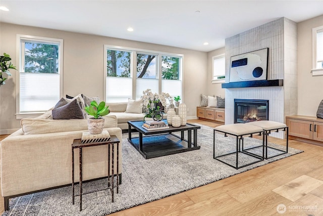 living area with light wood-style floors, a fireplace, recessed lighting, and baseboards