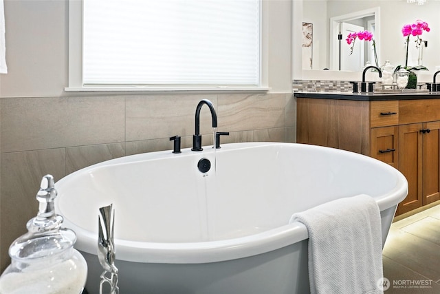 full bathroom featuring vanity, plenty of natural light, and a freestanding bath