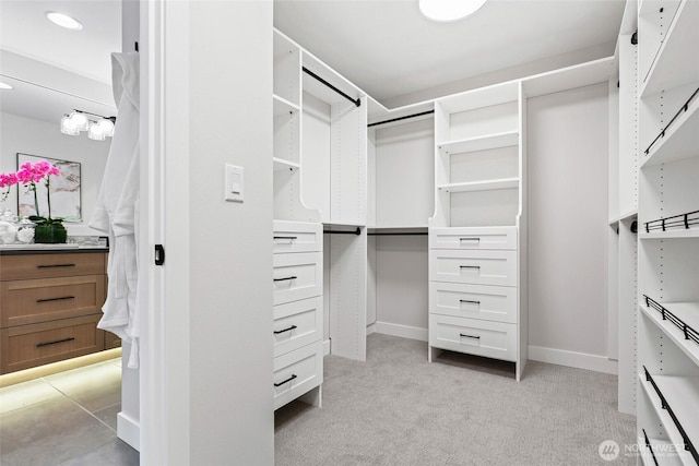 walk in closet featuring light colored carpet
