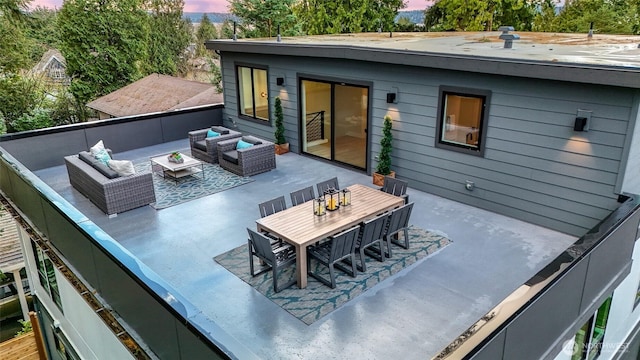 back of property at dusk featuring an outdoor living space, a patio, and outdoor dining space