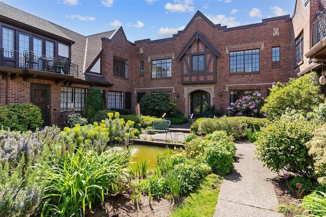 tudor-style house featuring brick siding