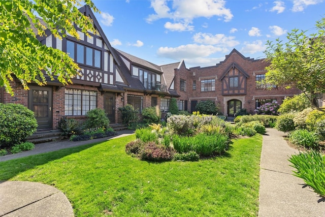 view of front of home with brick siding and a front yard
