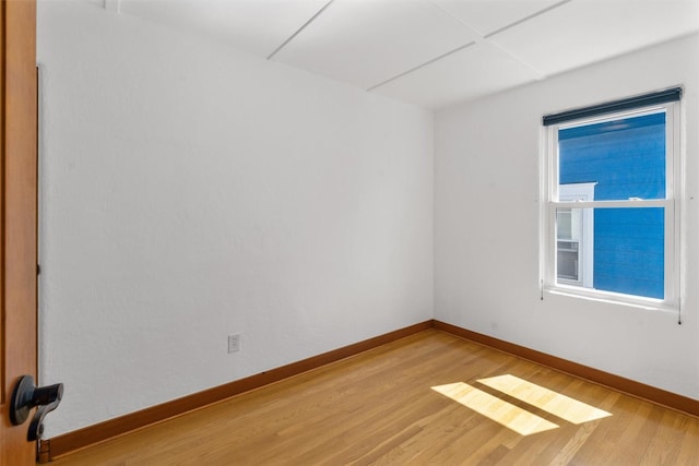 empty room with baseboards and light wood-style floors