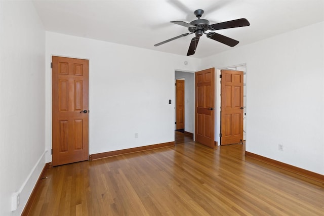 spare room featuring wood finished floors, baseboards, and ceiling fan