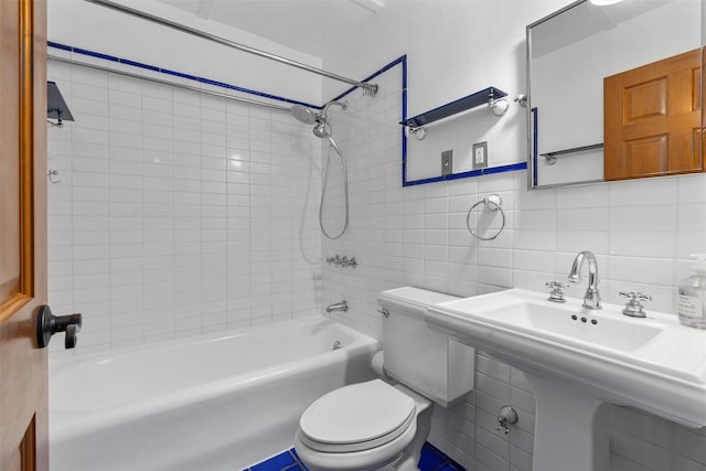 full bath with tile walls, toilet, shower / bath combination, decorative backsplash, and a sink