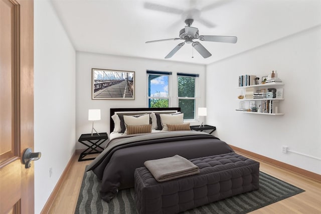 bedroom featuring wood finished floors, a ceiling fan, and baseboards