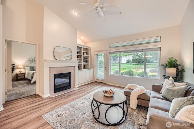 4313 S 220th Pl Unit 18-2, Kent, WA 98032 - living area with a tile fireplace, wood finished floors, ceiling fan, high vaulted ceiling, and baseboards