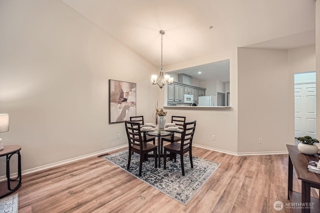 4313 S 220th Pl Unit 18-2, Kent, WA 98032 - dining area with light wood-style floors, a chandelier, baseboards, and high vaulted ceiling
