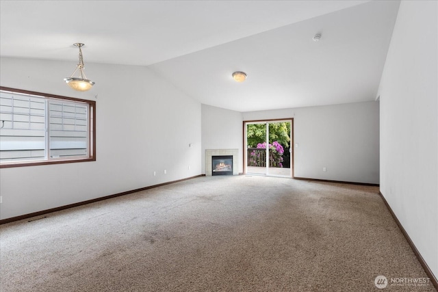 2323 Baird Ave, Snohomish, WA 98290 - unfurnished living room featuring carpet flooring, vaulted ceiling, baseboards, and a tiled fireplace