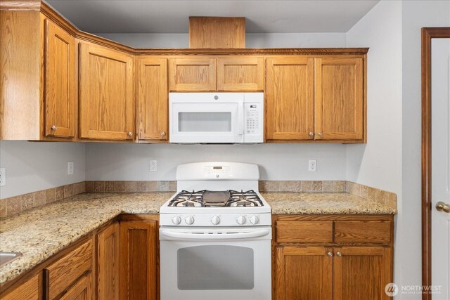 2323 Baird Ave, Snohomish, WA 98290 - kitchen with white appliances, brown cabinets, and light stone counters