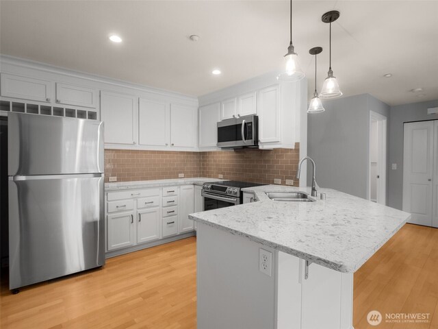 23925 NE 115th Ln Unit 302, Redmond, WA 98053 - kitchen with stainless steel appliances, a peninsula, light stone countertops, backsplash, and white cabinetry