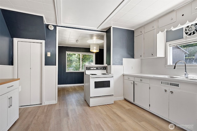 3510 N Puget Sound Ave, Tacoma, WA 98407 - kitchen with white electric range, a sink, light wood-style floors, light countertops, and white cabinetry