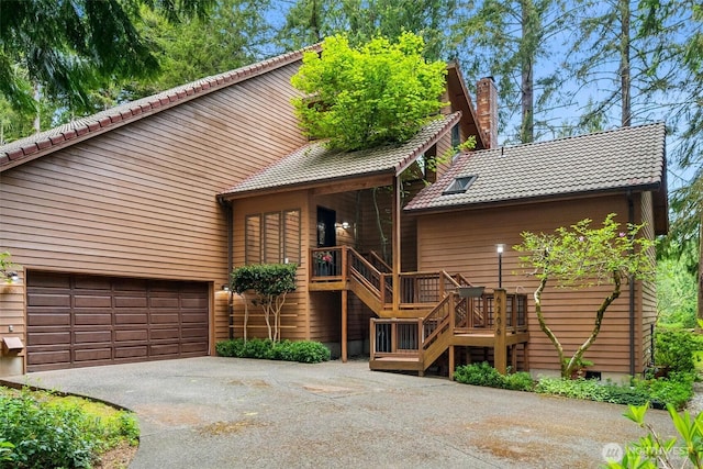 6206 SW Tiger Tail Dr, Olympia, WA 98512 - view of front of home with a tiled roof, asphalt driveway, stairs, a chimney, and an attached garage