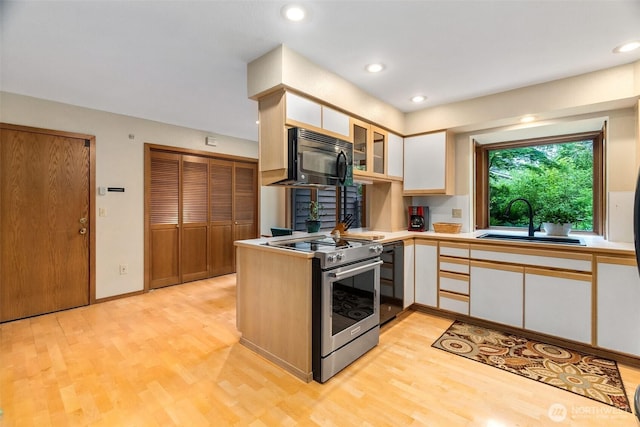 6206 SW Tiger Tail Dr, Olympia, WA 98512 - kitchen featuring stainless steel range with electric stovetop, black microwave, a sink, white cabinets, and light wood-type flooring