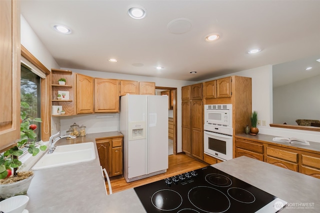 kitchen with white appliances, a sink, light wood-style floors, recessed lighting, and open shelves