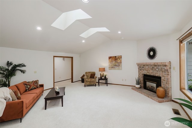 carpeted living room featuring vaulted ceiling, recessed lighting, a brick fireplace, a skylight, and baseboards